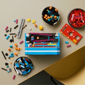 Lego Super Mario multicoloured brick set laid flat with sorted pieces in bowls, featuring blue, red, and yellow components