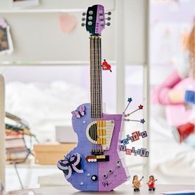 Lego Editions Music guitar building set in multi-colour purple with decorative details and two mini figures displayed on a desk