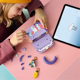 Child building Lego Creator Art Fashion Bag with Storage in multi colours, shown open with accessories, alongside a tablet display