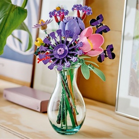 Lego Botanical wildflower bouquet set in multi colours, displayed in a green glass vase on a wooden surface