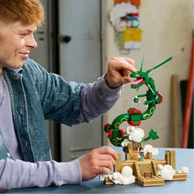 Model with Lego Pok&eacute;mon Rayquaza building set, posing green serpent dragon figure above cloud and temple base scene