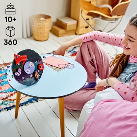 Girl playing with Lego Editions Music vinyl record-shaped toy set on a blue table, featuring colourful built figures and details