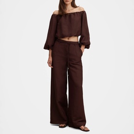 Model wearing Forever New chocolate wide-leg trousers styled with a matching off-shoulder crop top