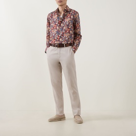 Model wearing Paul Smith Red Floral Single Cuff Slim shirt with stone linen trousers, brown belt, and beige suede desert boots.