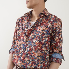 Model wearing Paul Smith red floral cotton slim fit shirt with single cuffs, styled with a white V-neck tee and brown belt.