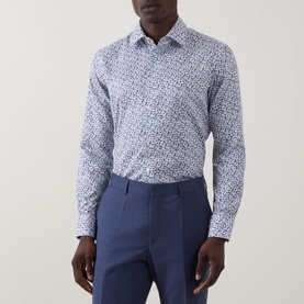 Model wearing Paul Smith white slim fit cotton formal shirt with blue floral print, styled with blue tailored trousers.