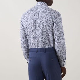 Model wearing Paul Smith white slim fit cotton formal shirt with small floral print, styled with navy blue trousers, seen from behind.