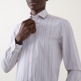 Model wearing Paul Smith Multi Blue slim fit striped cotton formal shirt, adjusting collar, with contrast cuff detail visible.