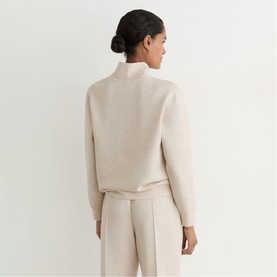 Model wearing Reiss neutral marl high-neck knit sweater, back view, styled with matching wide-leg trousers.