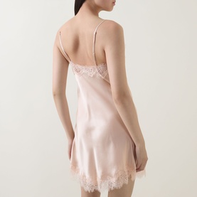 Model wearing Sainted Sisters Scarlett Silk Chemise in Shell, showing lace-trimmed back, adjustable straps, and curved hem mini length.