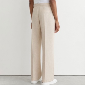 Model wearing Reiss neutral marl wide-leg trousers, rear view, styled with a white top. Relaxed fit with front pleats.