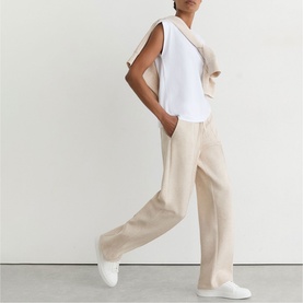 Model wearing Reiss neutral marl wide-leg trousers with white sleeveless top and white trainers.