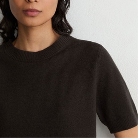 Model wearing Reiss grape burgundy short-sleeve knit top, close-up crop showing ribbed crew neck and soft knit texture.