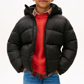 Model wearing Tommy Hilfiger black puffer jacket with hood, styled with red knit jumper and jeans.