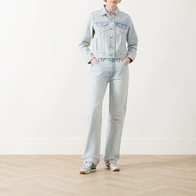 Model wearing Levi's The Original Trucker Jacket in De Oro Trucker light wash denim, styled with matching wide-leg jeans and blue trainers.