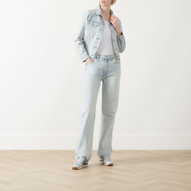 Model wearing Levis The Original Trucker Jacket in De Oro Trucker light wash denim, styled with matching wide-leg jeans and grey trainers.