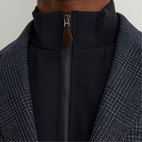 Model wearing Reiss blue check blazer, close-up of lapel and navy zip-up insert detail with brown leather zip pull