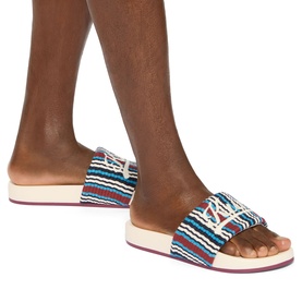 Model wearing Kurt Geiger London red multicolour striped flat slides with white flatform sole and buckle strap detail