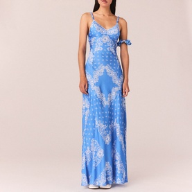 Model wearing blue bandana-print satin maxi dress with sweetheart neckline, thin straps with tie detail, and flared hem