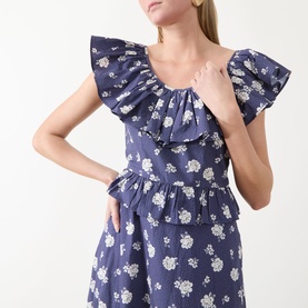 Model wearing Queens of Archive Devon Prairie Floral Dress in Prairie Rose Blue with scoop frill neck and peplum waist detail