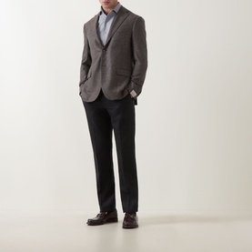 Model wearing grey textured blazer styled with light blue shirt, dark trousers and brown leather shoes
