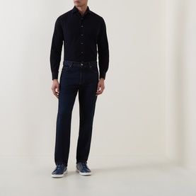 Model wearing Corneliani navy cotton casual shirt with dark indigo jeans and navy trainers, full-length view