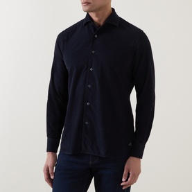 Model wearing Corneliani navy cotton casual shirt with spread collar and button placket, styled with dark jeans