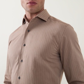 Model wearing Corneliani Herringbone Tonal Striped Shirt in beige, featuring spread collar, front button fastening and subtle tonal stripe pattern.