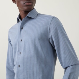 Model wearing Corneliani Herringbone Tonal Striped Shirt in mid blue, featuring spread collar, front button fastening and long sleeves.