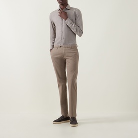 Model wearing taupe slim-fit chinos with a fitted mauve shirt and navy espadrilles