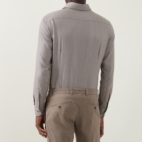 Model wearing grey long-sleeve button shirt, styled with beige chinos, rear view