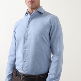Model wearing Corneliani light blue cotton casual shirt with spread collar and button placket, styled with dark trousers and brown belt
