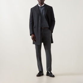 Model wearing a charcoal wool overcoat, styled with grey trousers, knit jumper, white shirt and black loafers