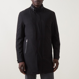 Model wearing Corneliani Technical Padded Coat in black, featuring high neckline, zip fastening and zipped side pockets.