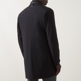 Model wearing Corneliani Technical Padded Coat in black, rear view showing logo tab, high neckline and long sleeves.