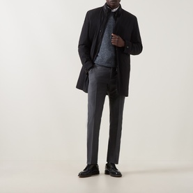 Model wearing Corneliani Technical Padded Coat in black with high neckline, styled with grey knit and tailored trousers