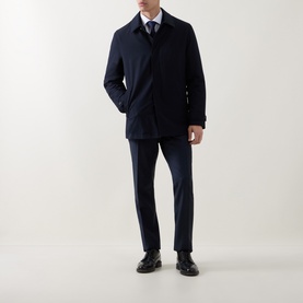 Model wearing Corneliani Technical Waterproof Car Coat in navy, styled with matching trousers, white shirt, tie and black leather shoes.
