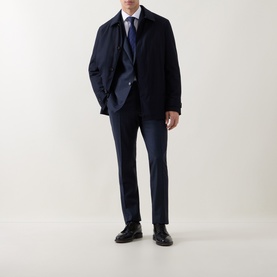 Model wearing Corneliani Technical Waterproof Car Coat in navy, styled with matching navy suit trousers, white shirt, blue tie and black shoes.