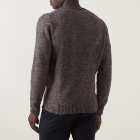 Model wearing Corneliani Chunky Knit Sweater in brown, crew neck, ribbed trims, alpaca blend. Styled with navy trousers. Rear view.