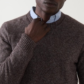 Model wearing Corneliani Chunky Knit Sweater in brown, crew neck with ribbed trims, styled over a light blue collared shirt.