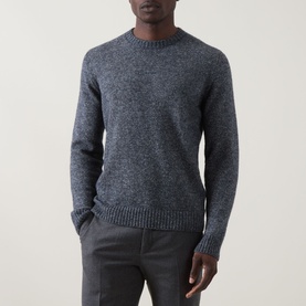 Model wearing Corneliani Chunky Knit Sweater in blue, crew neck, ribbed trims, styled with grey trousers.