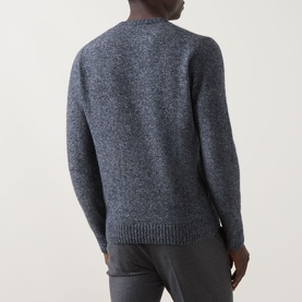 Model wearing Corneliani Chunky Knit Sweater in blue, crew neck with ribbed trims, paired with grey trousers. Rear view.