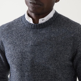 Model wearing Corneliani Chunky Knit Sweater in blue marl, crew neck with ribbed trim, styled over a white shirt collar.