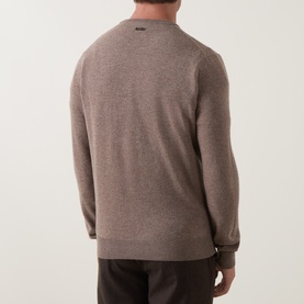 Model wearing Corneliani Logo Knitted Sweater in taupe, crew neck, rear logo detail, ribbed trims, paired with dark trousers.