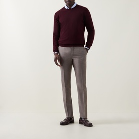 Model wearing Corneliani Burgundy Crew Neck jumper in wool-cashmere blend, styled with grey tailored trousers and a blue shirt.
