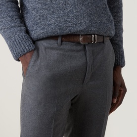 Model wearing Corneliani Straight Leg Formal Trousers in grey wool, with belt loops and pressed creases, styled with a blue knit sweater and brown
