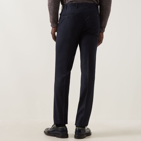 Model wearing Corneliani Straight Leg Formal Trousers in navy, rear view showing pressed creases and rear welt pockets, styled with black loafers.