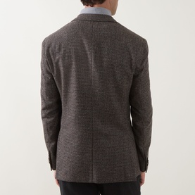 Model wearing Corneliani brown virgin wool blend jacket, rear view showing tailored seam detail and light blue shirt collar visible at neckline