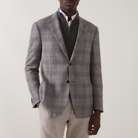 Model wearing Corneliani stone check wool blazer, styled with grey knit vest, white shirt and taupe trousers
