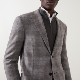 Model wearing Corneliani stone check wool jacket, styled with a grey zip-neck gilet and white shirt